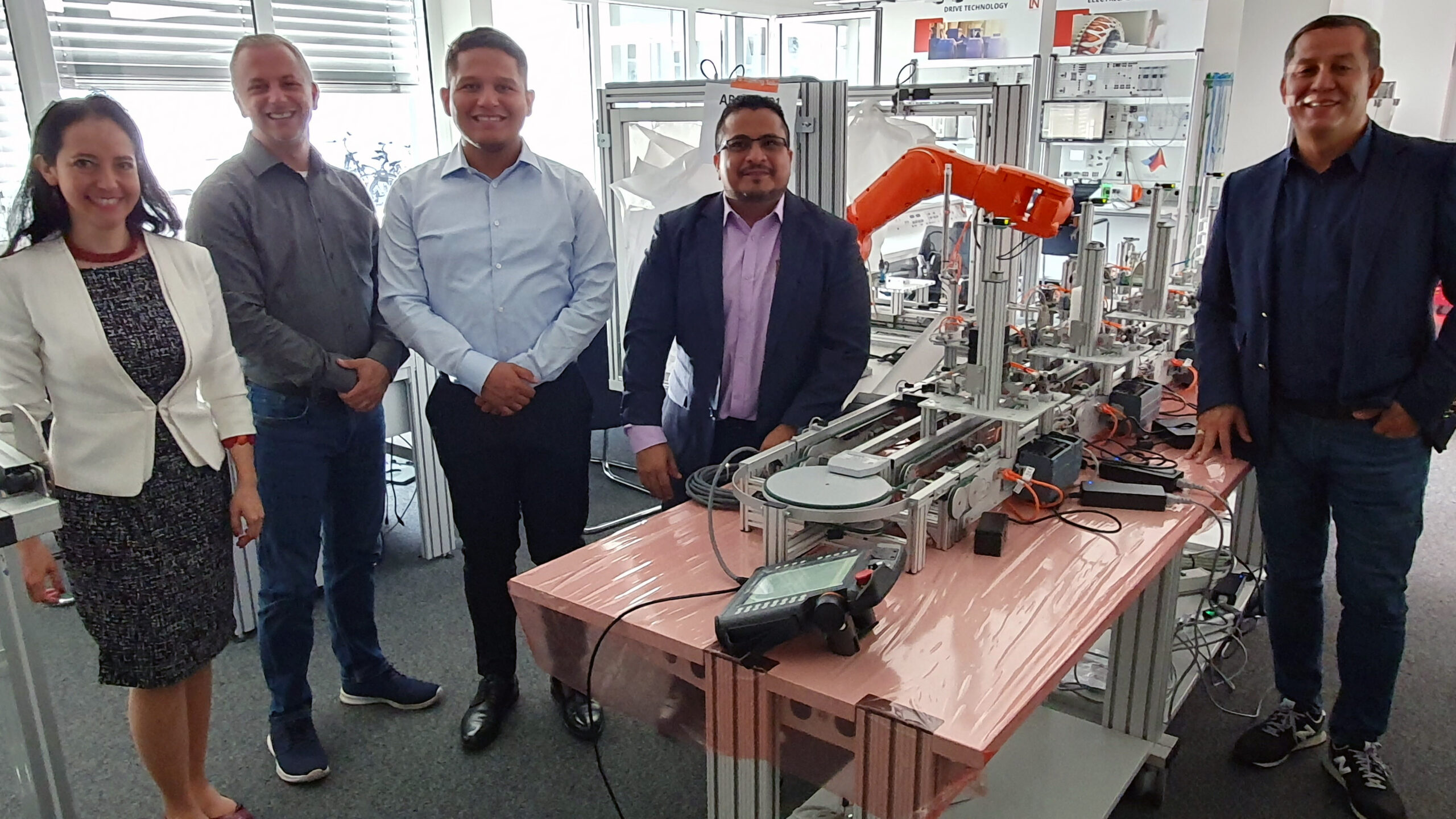 5 Personen vor einer 4.0-Trainingsanalage von Lucas-Nülle